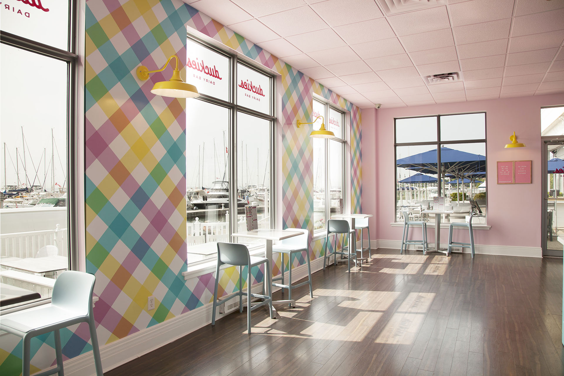Interior of Duckies Dairy Bar with tables and chairs in front of large windows.